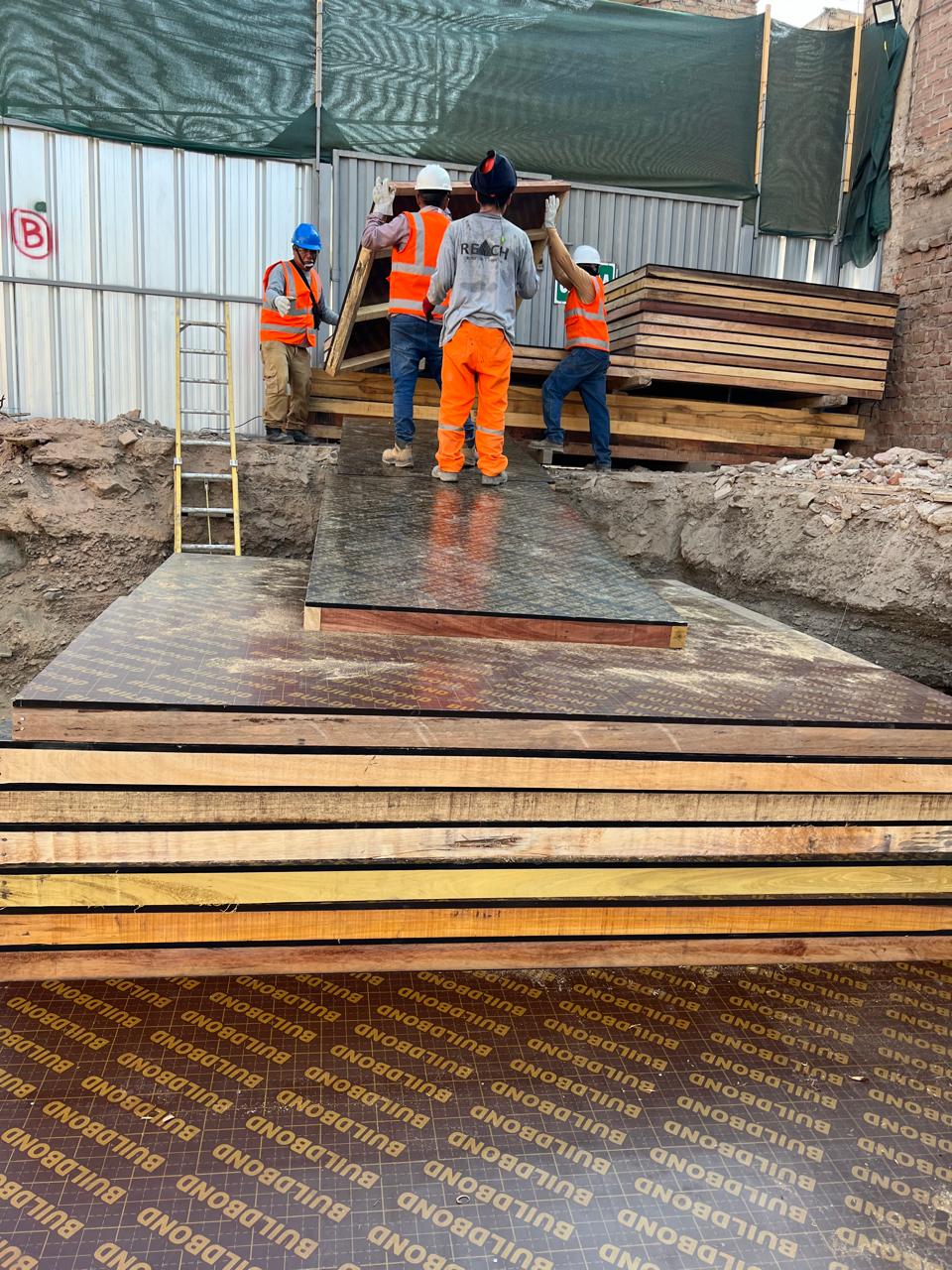 Equipo de obra manipulando tableros para construcción